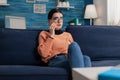 Student talking on the phone sitting on couch in living room. Royalty Free Stock Photo