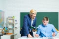 Student and teacher at college. Instructor in training class with students. Portrait of young teacher helping a student