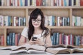 Student texting in the library Royalty Free Stock Photo