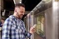 Student traveler waiting for train listening to music on a smartphone. Concept of leisure, communication, social media