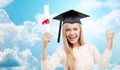 Student in trencher cap with diploma over blue sky