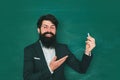Student and tutoring education concept. School concept. Knowledge day. Young bearded teacher near chalkboard in school Royalty Free Stock Photo