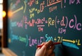 Student writes mathematical equations on a chalkboard in a classroom setting Royalty Free Stock Photo