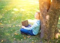 Student using his laptop in autumn city park Royalty Free Stock Photo