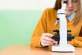 Student using microscope to examine samples in biology class. Royalty Free Stock Photo