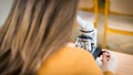 Student using microscope to examine samples in biology class. Royalty Free Stock Photo