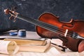 Student violin and equipment on wooden table and blackboard background