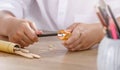 A student in white shirt sharpening a pencil using a small, yellow pencil sharpener. Royalty Free Stock Photo