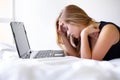 Student woman, laptop and stress on bed with mistake for exam, assessment or test with online course. Girl, studying and Royalty Free Stock Photo