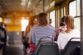 Student women taking a ride in public transport from the work at sunset time