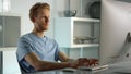 Student working studying home closeup. Confident ginger man writing check email.