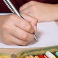 Student writing with hand in his exercise book at school Royalty Free Stock Photo