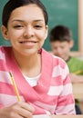 Student writing in notebook in school classroom Royalty Free Stock Photo