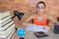 Student, Girl write in notebook between books. Girl working on his homework. young attractive student Girl studying lessons Royalty Free Stock Photo