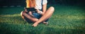 Studente in park e-learning on tablet PC sitting cross-legged on the grass Royalty Free Stock Photo