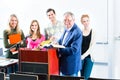 Students asking professor in college auditorium Royalty Free Stock Photo