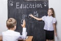 Students boy and gir at the Desk on the background of the slate Royalty Free Stock Photo