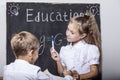 Students boy and girl at the Desk on the background of the slate Royalty Free Stock Photo