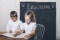 Students boy and girl at the Desk on the background of the slate Royalty Free Stock Photo