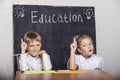 Students boy and girl at the Desk on the background of the slate Royalty Free Stock Photo