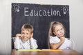 Students boy and girl at the Desk on the background of the slate Royalty Free Stock Photo