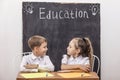 Students boy and girl at the Desk on the background of the slate Royalty Free Stock Photo