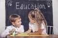 Students boy and girl at the Desk on the background of the slate Royalty Free Stock Photo