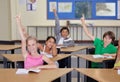 Students, classroom portrait and raise hands for questions, education or learning for geography quiz in school. Happy