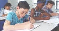 Students in classroom solving math problems, focusing on their work