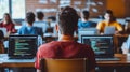 Students in a coding bootcamp classroom learn programming on laptops as their focused instructor delivers a lesson from the front Royalty Free Stock Photo