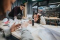 Students collaborate at a workshop table, using laptops and phones during a group study session Royalty Free Stock Photo