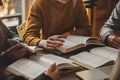 Students Group Studying Together Open Books Education Learning Teamwork text desk focus pages words paper table hands Royalty Free Stock Photo