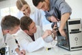 Students in computing class with teacher fixing computer Royalty Free Stock Photo