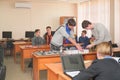 Students connect wires control panel with small test bench for experiments