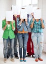 Students covering faces with blank papers Royalty Free Stock Photo