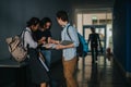 Students discussing notes in hallway during class transition Royalty Free Stock Photo