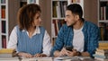 Students do homework in library teamwork working on joint project cute girl explaining task to male friend write notes Royalty Free Stock Photo