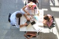 Students doing group projects while sitting on table at university library