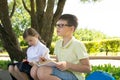 Students doing homework, in the park in the fresh air, a boy with glasses, thought about the task Royalty Free Stock Photo