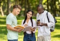 Students Engaging in Study Session Outdoors in a Sunny Park Setting With Notebooks and Coffee Royalty Free Stock Photo