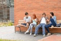 Students friends sitting bench outside campus