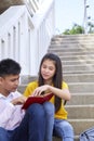students friends sitting on stairs using book Royalty Free Stock Photo