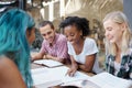 Students, friends and study outdoor at university with books, laptop and learning for education and campus. Group, gen z Royalty Free Stock Photo