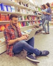 Students with gadget at the bookshop Royalty Free Stock Photo