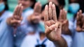 Students girl showing three finger salute in school.16:9 style