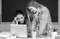 Students girls looking at laptop computer in classroom at school college. Two students doing homework together and Royalty Free Stock Photo