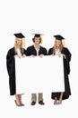 Students in graduate robe holding a blank sign