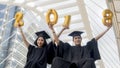 Students in graduation suit sit and gold number balloons 2018