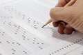 Students hand doing exams quiz test paper with pencil