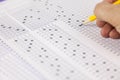 Students hand doing exams quiz test paper at school